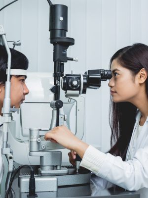 Consultation with an ophthalmologist. Young asian man and woman doctor in clinic office. Medical equipment